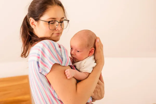 若いです疲れ母保持彼女の新生児上の彼女の肩 — ストック写真