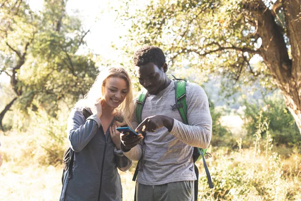 Das junge Paar sucht einen Weg im Wald — Stockfoto