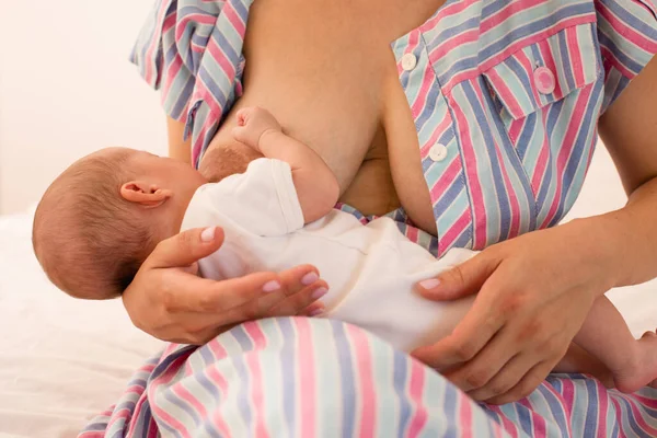 A mãe está amamentando seu bebê recém-nascido na cama — Fotografia de Stock