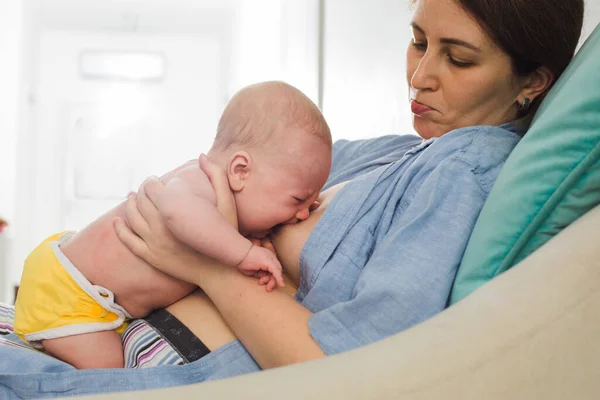 A jovem mãe quer amamentar seu bebê recém-nascido — Fotografia de Stock