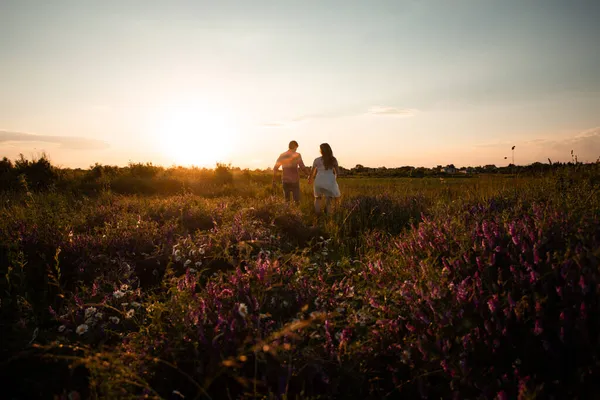 Lovely couple walking in the summer field — Stock Photo, Image