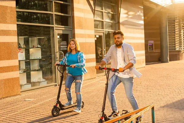 这对年轻夫妇在城里花时间一起骑电动车 — 图库照片
