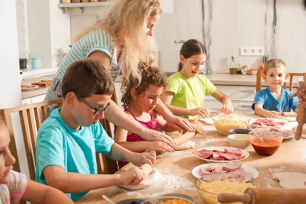 O professor está aprendendo as crianças a cozinhar pizza — Fotografia de Stock