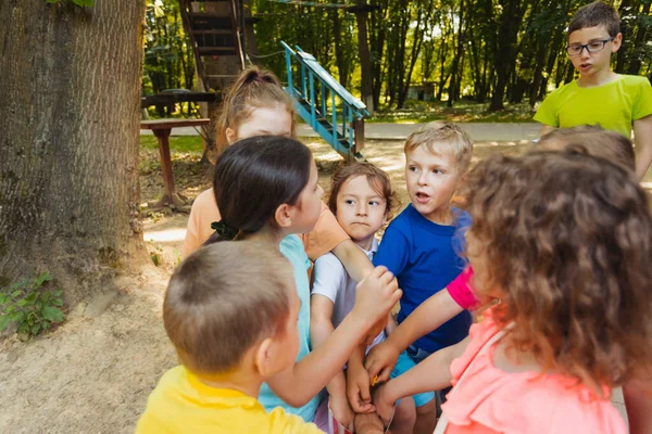 El grupo de niños pequeños comparte palomitas de maíz en el parque — Foto de Stock