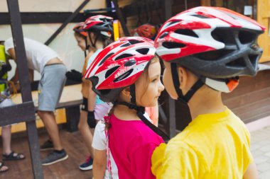 Çocuklar halat parkında güvenli bir tırmanışa hazırlanıyorlar.