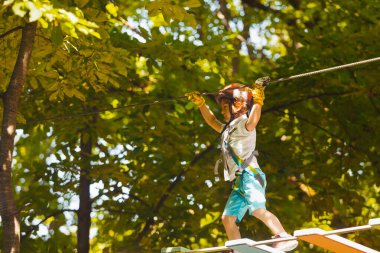 Tatlı anaokulu öğrencisi macera parkında oynuyor.