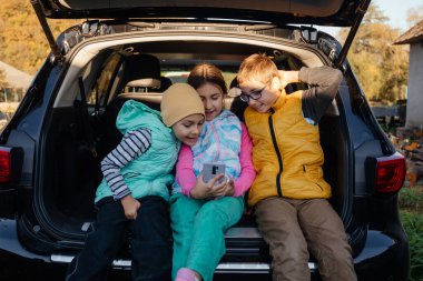 Bir grup çocuk akıllı telefonla selfie çekiyor.
