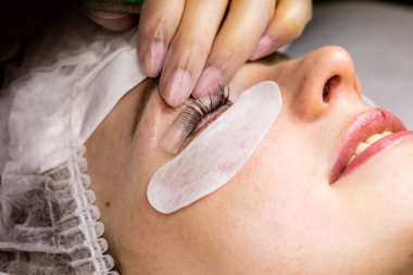 Güzellik salonunda kirpik kırbaçlama prosedürü altında bir kadın yüzü