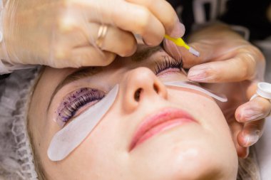 Güzellik salonunda kirpik kırbaçlama prosedürü altında bir kadın yüzü