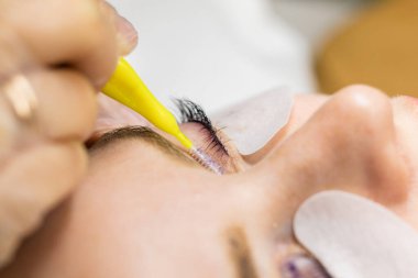 Güzellik salonunda kirpik kırbaçlama prosedürü altında bir kadın yüzü