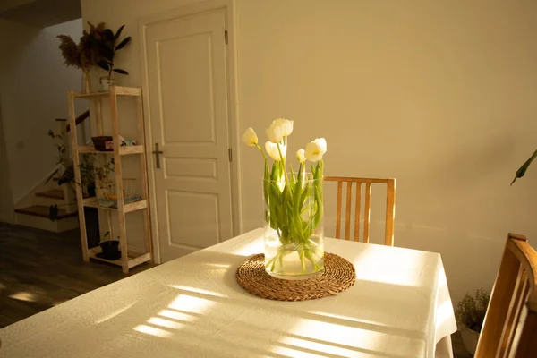 Flores de primavera - tulipas brancas em vaso de vidro em mesa de madeira — Fotografia de Stock