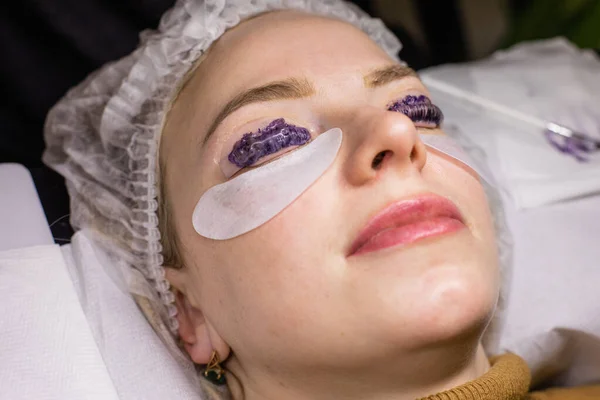 La cara femenina bajo el procedimiento de la laminación de las pestañas en el salón de belleza — Foto de Stock