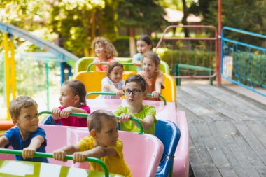 Lunaparktaki lunaparkta hız trenindeki mutlu çocuklar.