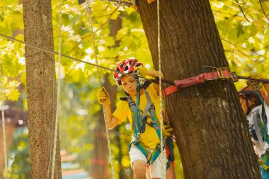Tatlı anaokulu öğrencisi macera parkında oynuyor.