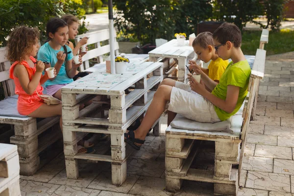 De kinderen eten ijs in het café. — Stockfoto
