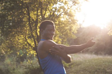 Güçlü genç adam parkta antrenman yapıyor.