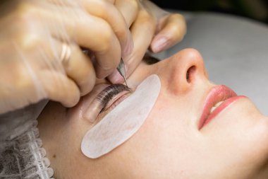Güzellik salonunda kirpik kırbaçlama prosedürü altında bir kadın yüzü