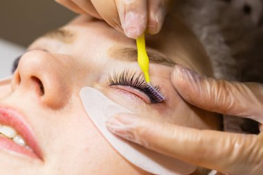 Güzellik salonunda kirpik kırbaçlama prosedürü altında bir kadın yüzü