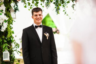 Düğün töreninde, çiçek kemerinin altında bir çift.