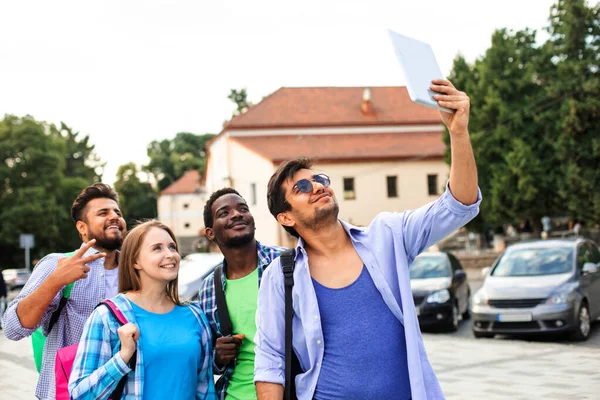 Radostná skupinka mnohonárodnostních studentů, kteří chodí ven na selfie — Stock fotografie