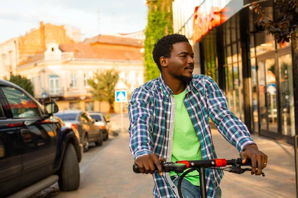 Młody człowiek ze skuterem pozuje w mieście. — Zdjęcie stockowe