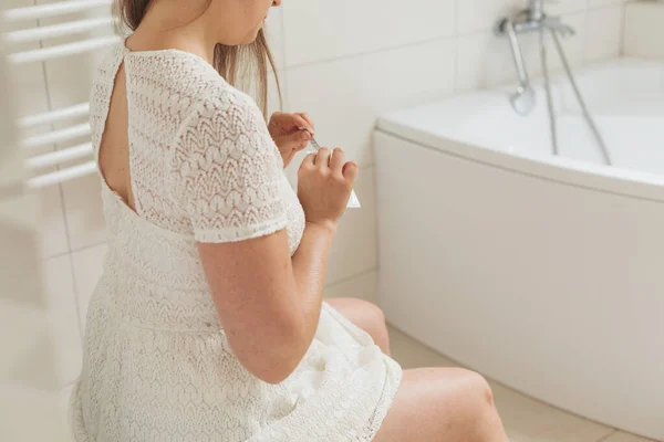 Žena středního věku s těhotenským testem na toaletě — Stock fotografie