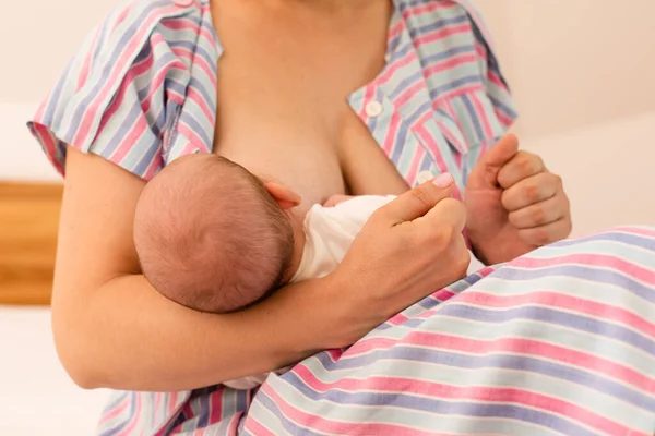 La madre amamanta a su bebé recién nacido en la cama — Foto de Stock