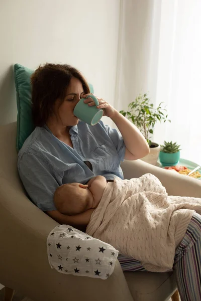 新生児の母乳育児中に女性がお茶やコーヒーを飲む — ストック写真
