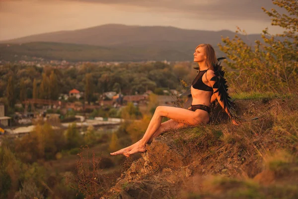 丘の上に黒い天使の羽を持つ女性 — ストック写真