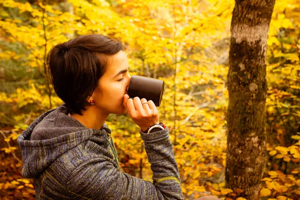 Młoda kobieta pije filiżankę ciepłej herbaty lub kawy — Zdjęcie stockowe