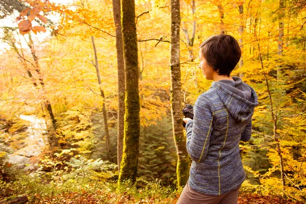 Kobieta trekking w lesie i robienie zdjęć z kamery dlsr — Zdjęcie stockowe