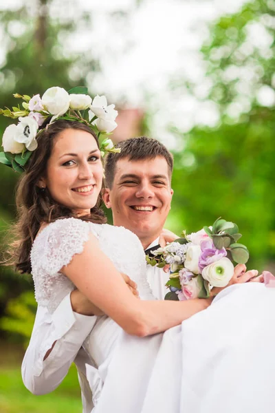 Glücklicher Hochzeitstag. Bräutigam hält die Braut — Stockfoto