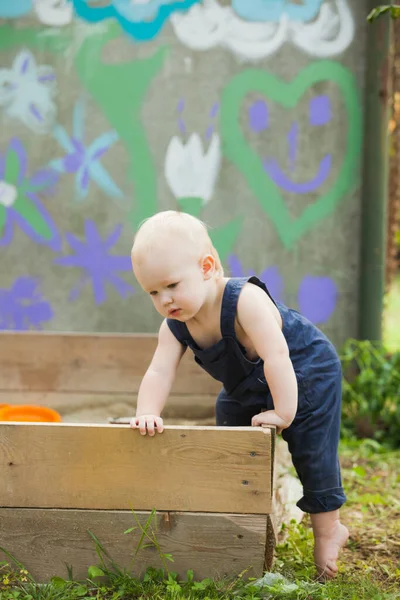 O bebê solitário está brincando no jardim de verão — Fotografia de Stock