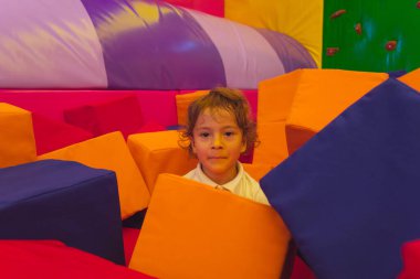 Tatlı çocuk yumuşak küplerin arasında duruyor.