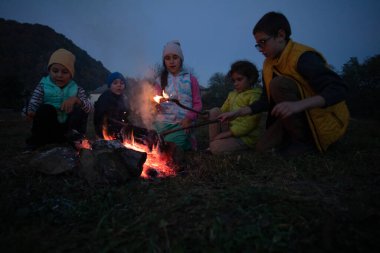 Yürüyüşten sonra çocuklar piknik yapar - bir grup mutlu arkadaş