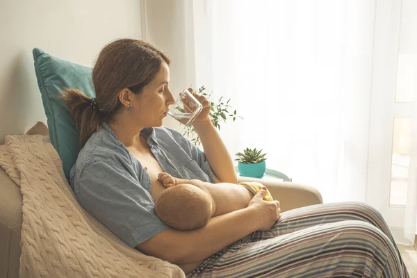 Comfortable and supported breastfeeding. Woman drink water — Stock Photo, Image