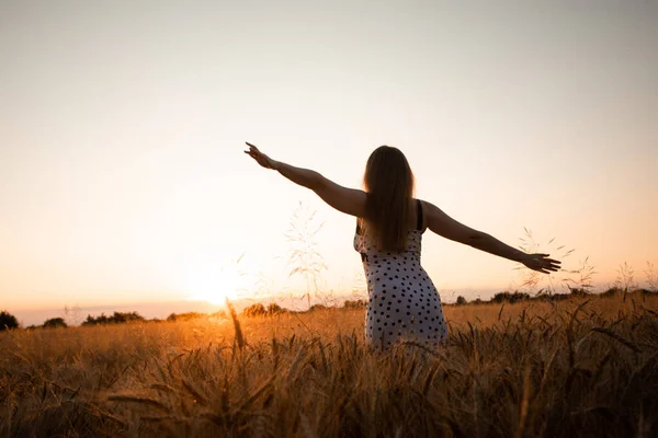 野原で太陽が昇るのを歓迎する平和的な女性 — ストック写真