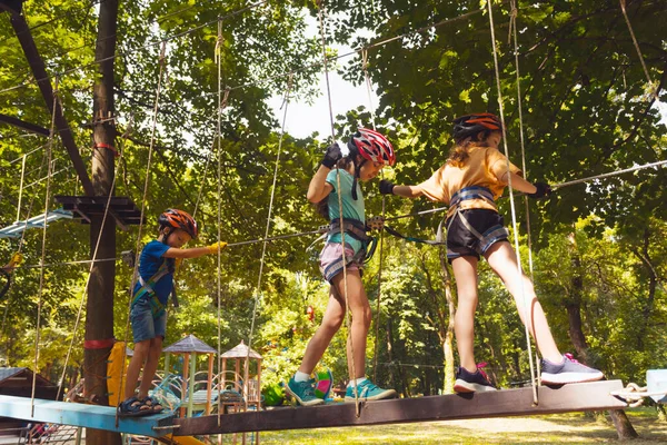 De geconcentreerde kinderen klimmen in het hoge touwenpark — Stockfoto