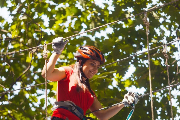 Genç bayan eğitmen halat parkındaki kıyafetleri kontrol ediyor.