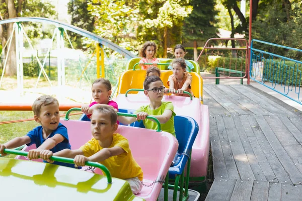 Los niños pequeños felices están descansando en el parque de atracciones — Foto de Stock