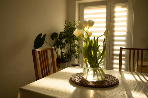 Bahar çiçekleri - ahşap masada cam vazoda beyaz laleler