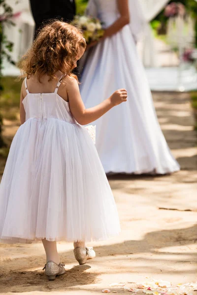 The little girl and brides at the outdoor ceremony — Stock Photo, Image