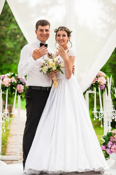 結婚式で花のアーチの下の結婚式のカップル — ストック写真