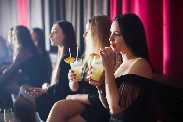 Mulheres se divertem e bebem coquetéis com frutas — Fotografia de Stock