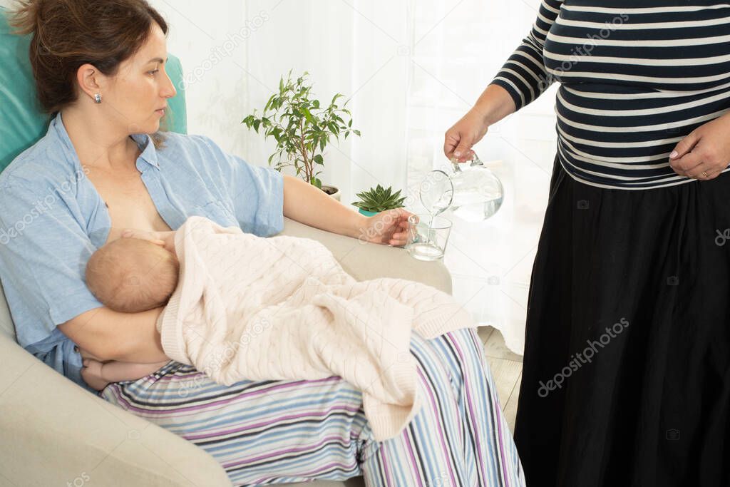 Comfortable and supported breastfeeding. Woman drink water