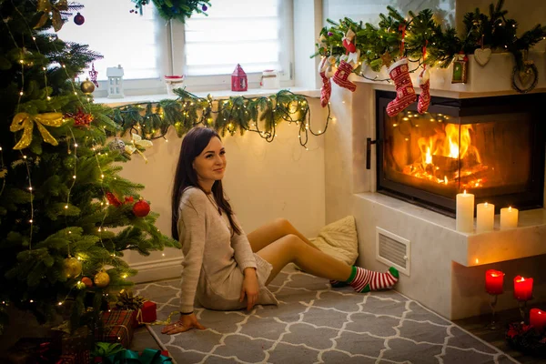 Woman sitting near the fireplace at the Christmas — ストック写真