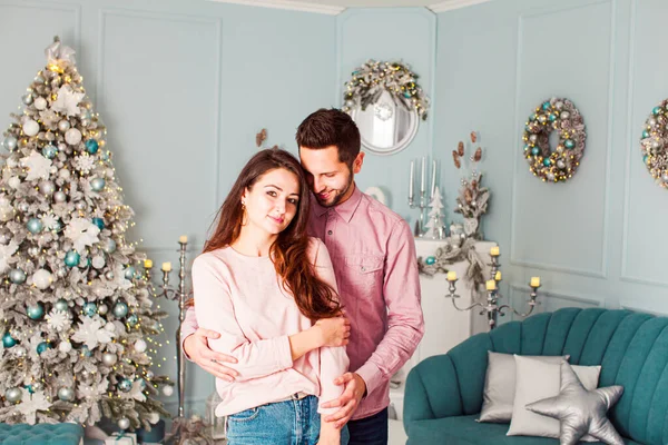 Young happy couple have fun and huggingnear christmas tree — Stockfoto
