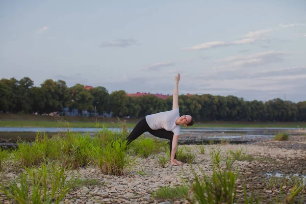 Молода жінка робить йогу на каменях у природі — стокове фото