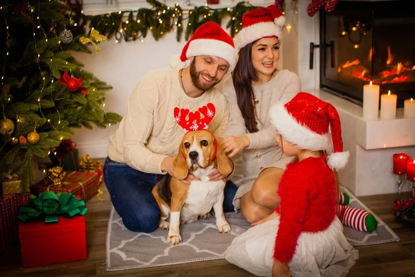 Famiglia seduta vicino a un bellissimo albero di Natale a casa — Foto Stock