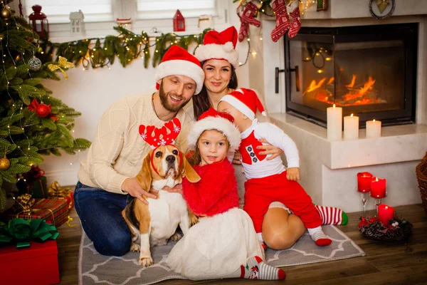 Famiglia seduta vicino a un bellissimo albero di Natale a casa — Foto Stock